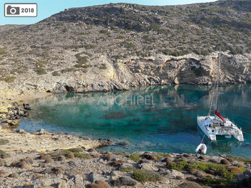 The catamaran at anchor in a quiet bay.